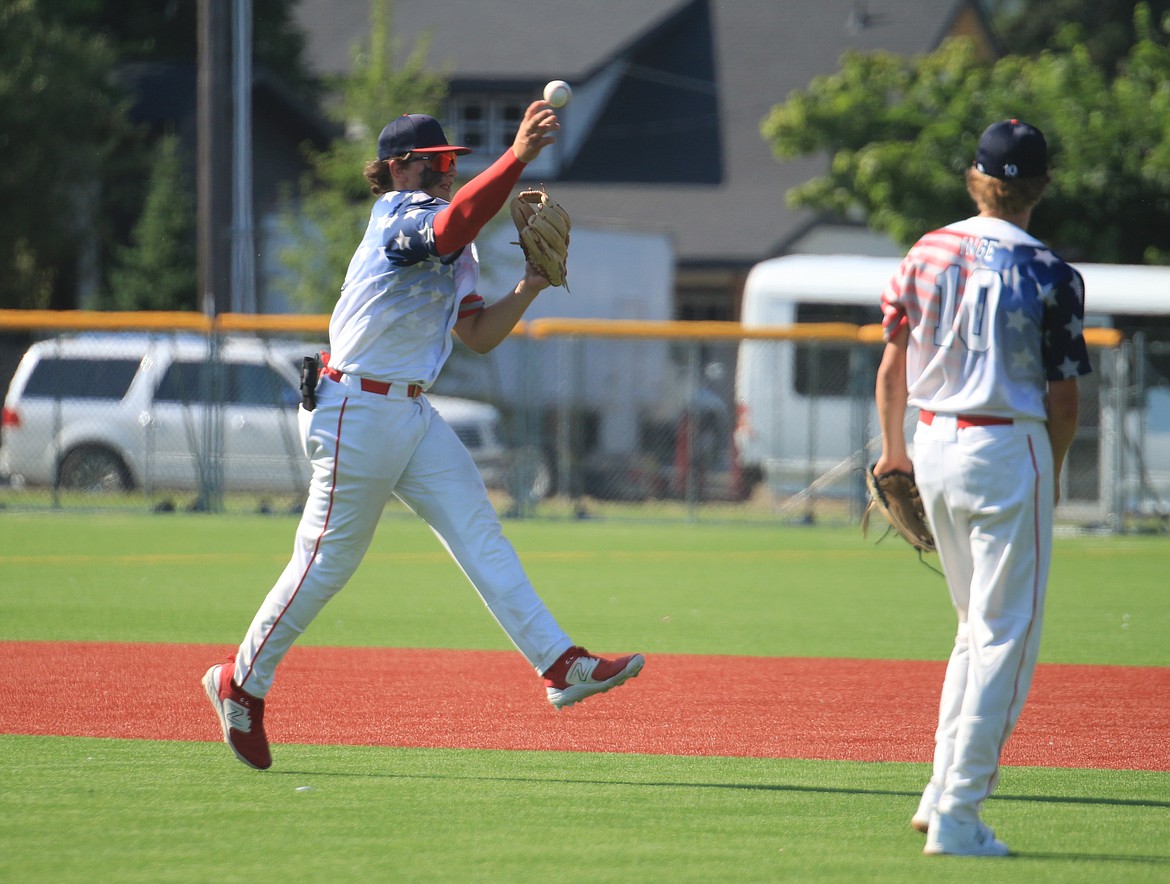 Second baseman Jorden Tyler charges a ground ball and throws to first on the run during the first game against Camas Prairie.