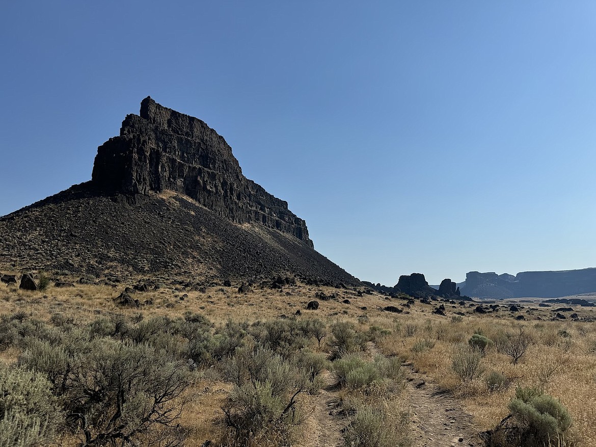 This photo was taken from the Umatilla Rock Trail which is roughly three miles long and passes by Perch and Dry Falls lakes in Sun Lakes Dry Falls State Park near Coulee City. Nearby trails also lead to Meadow Lake and Green Lake – look at a map ahead of time if you go. Timing may be an important consideration to think of where shade from various rises will be during yoru visit. Visiting a lake may be a good notion over the next week with most days predicted to be near 100 degrees.