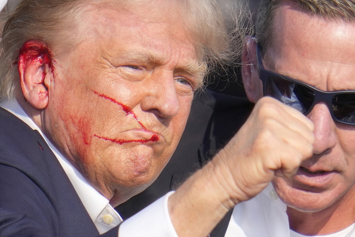 Republican presidential candidate former President Donald Trump gestures while surrounded by U.S. Secret Service agents as he is helped off the stage at a campaign rally in Butler, Pa., Saturday, July 13, 2024. (AP Photo/Gene J. Puskar)