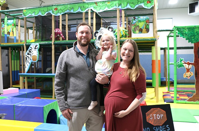 Caylor and Cathryn Bax are pictured with their daughter near the colorful and expansive play area at their new business, PonderPlay.