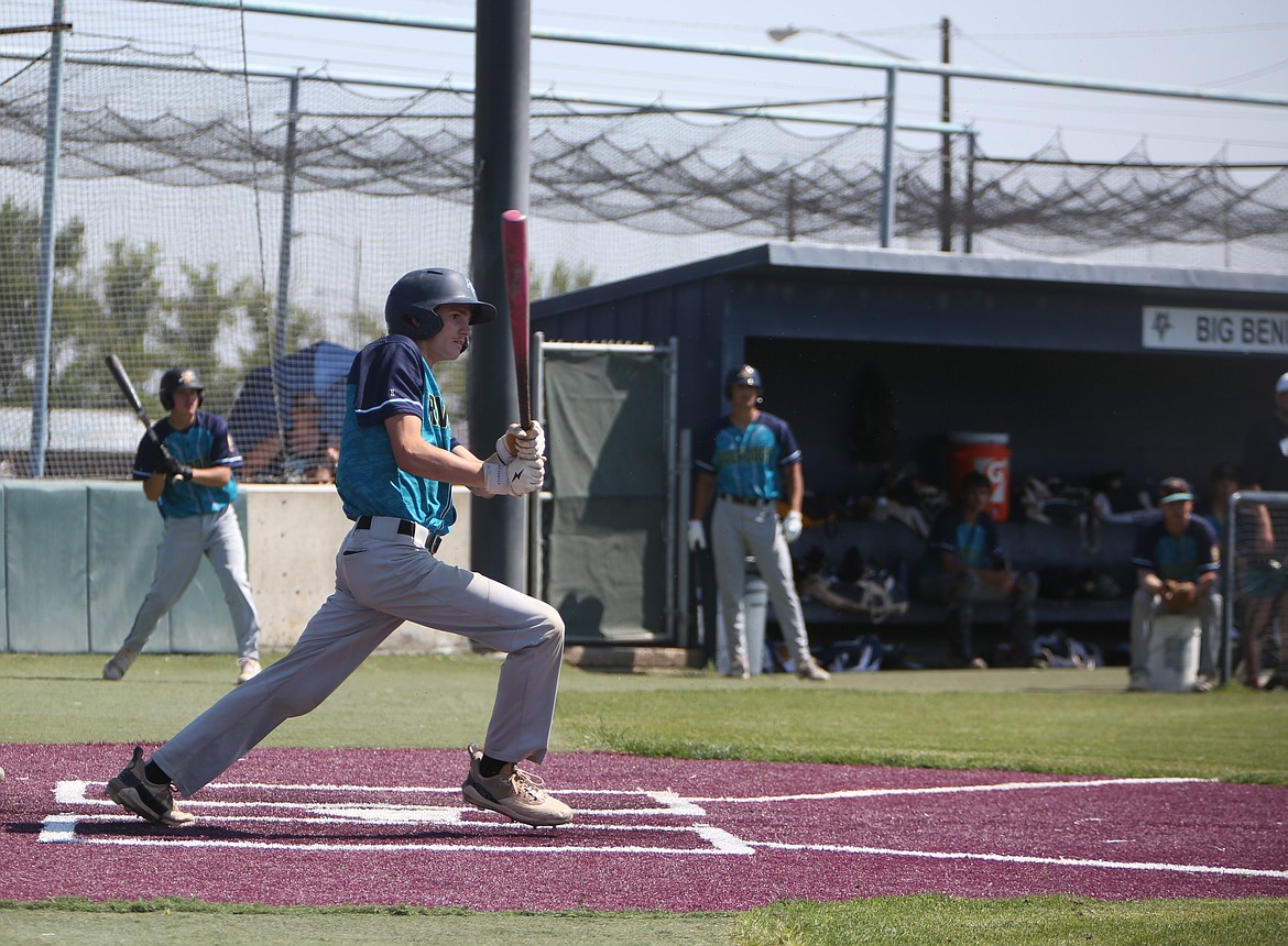 River Dog catcher Blaine Macdonald follows where the ball goes after being hit during a pool play game against Penticton on Saturday.