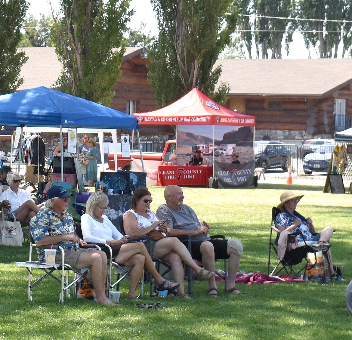 Festival attendees soak up the shade at the Soap Lake Food and Folk Festival Saturday. The mercury soared to 101 degrees, but many people stayed the entire 12 hours even so.