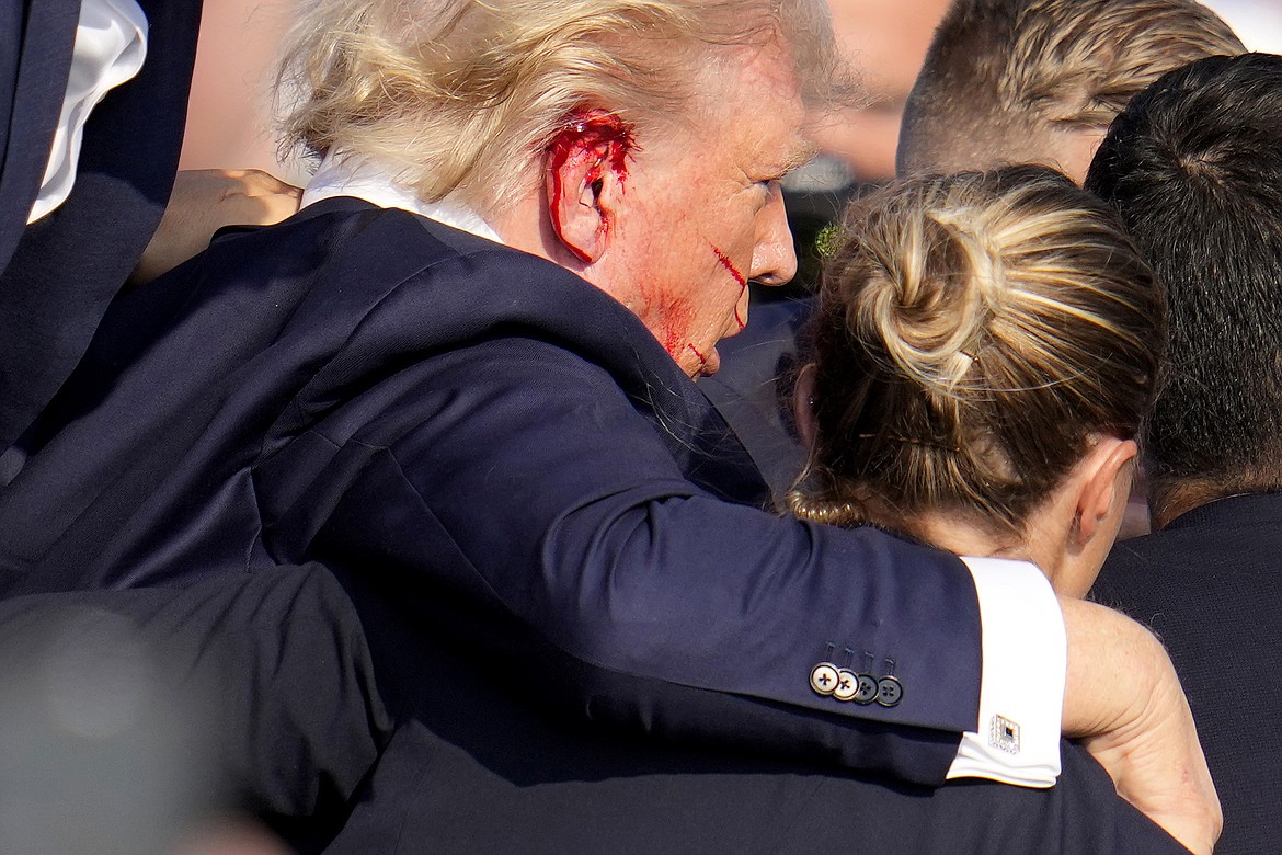 Republican presidential candidate former President Donald Trump is helped off the stage by U.S. Secret Service agents at a campaign event in Butler, Pa., on Saturday, July 13, 2024. (AP Photo/Gene J. Puskar)