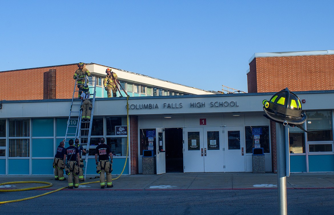 Firefighters break down hoses and ladders after fighting a fire at the Columbia Falls High School Monday night. (Hungry Horse News)