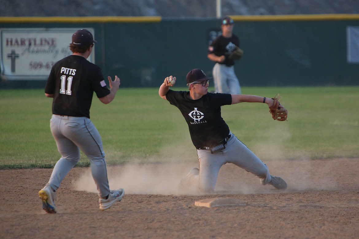 After diving down to field a ground ball, Almira/Coulee-Hartline Legion second baseman Caden Correia, right, throws the ball back to first base for an out against Gonzaga Prep on Friday. Correia picked up four total hits in Saturday’s doubleheader against Ferris.