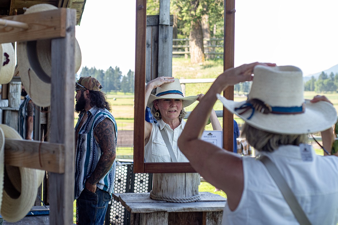 A festival-goer tries on hats at the Glacier Rim Hats booth at Under the Big Sky Friday, July 12. (Avery Howe/Bigfork Eagle)