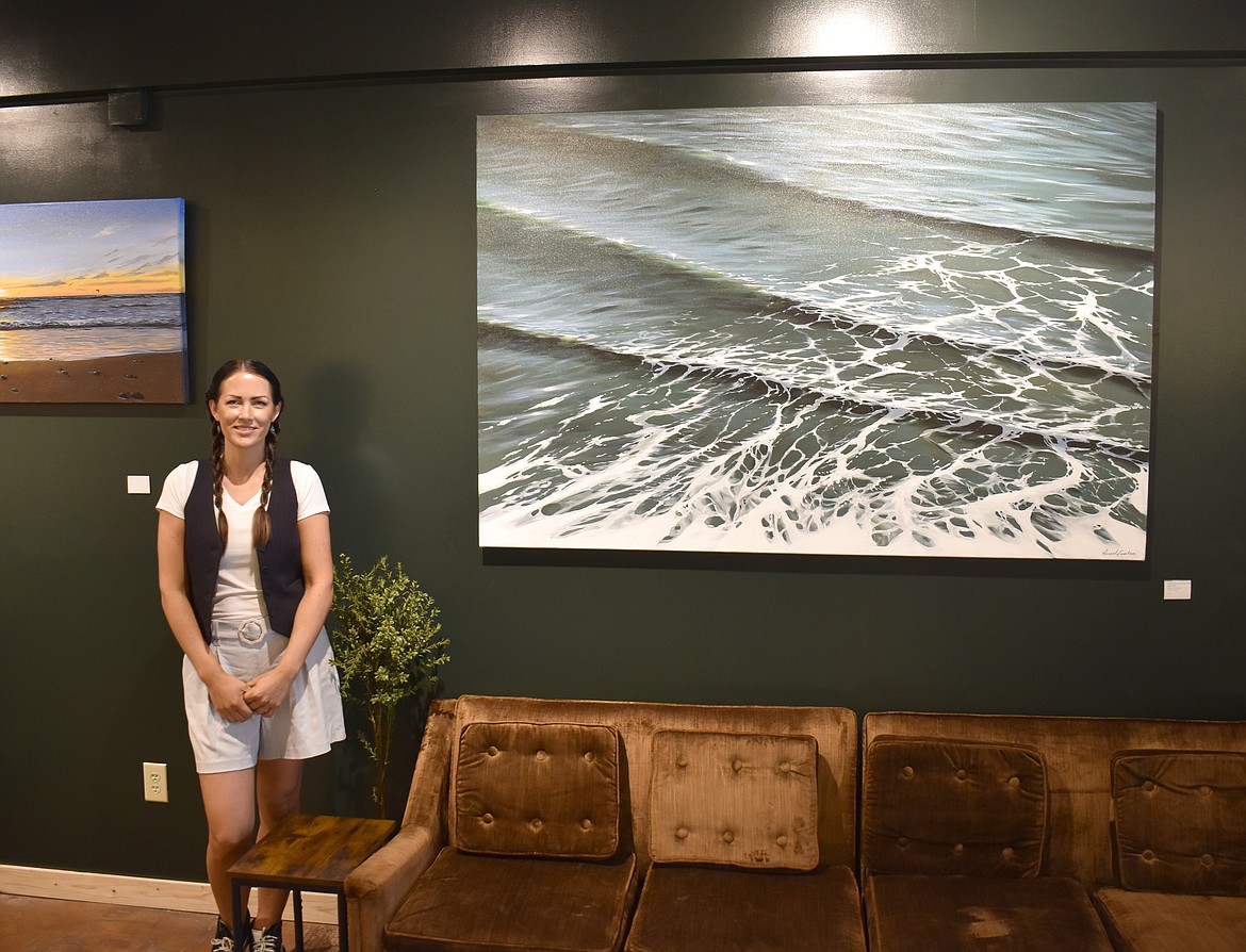 Moses Lake artist Hannah Fountain stands in her gallery The Drip beside one of her paintings, a 48x62 acrylic entitled “Healing.” The name reflects the healing effect the ocean can have on trauma, she said.