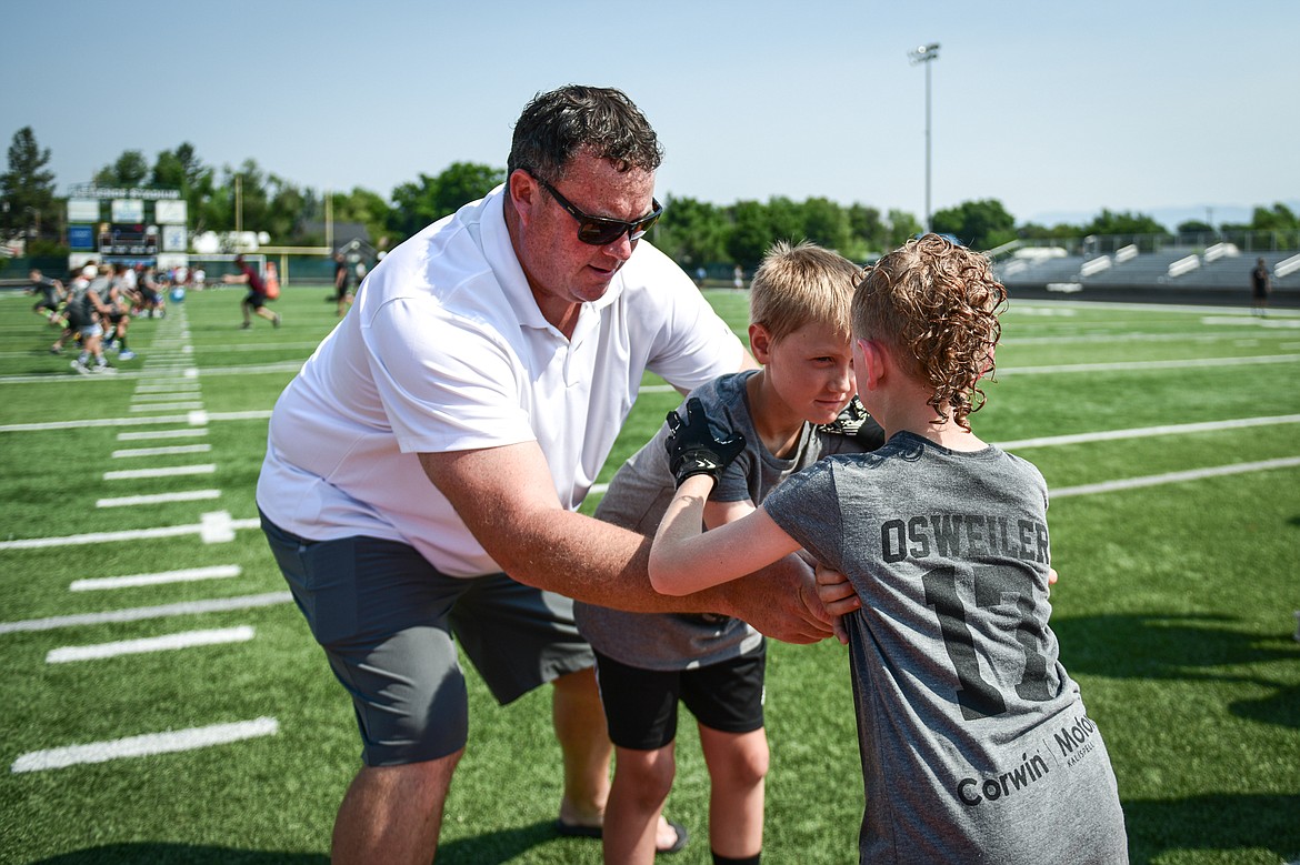 Former NFL and University of Montana lineman, and Flathead High alum, Dylan McFarland works with young campers during a blocking drill at the Flathead Braves Football Camp hosted by former NFL and Flathead Braves quarterback Brock Osweiler at Legends Stadium on Saturday, July 20. (Casey Kreider/Daily Inter Lake)