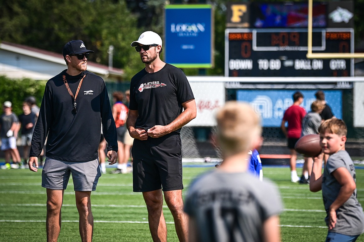 Former NFL and Flathead Braves quarterback Brock Osweiler, right, and Braves head football coach Caleb Aland watch campers during a throwing drill at the Flathead Braves Football Camp at Legends Stadium on Saturday, July 20. (Casey Kreider/Daily Inter Lake)