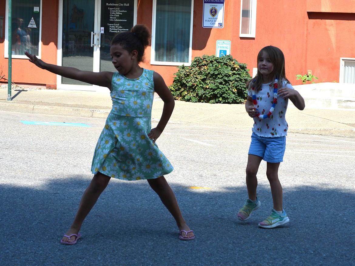 Friends Brenda Wooley and Kennedy Johnson dance in the streets to the song, "Cotton Eye Joe" as they wait for the Rathdrum Days Parade to begin.