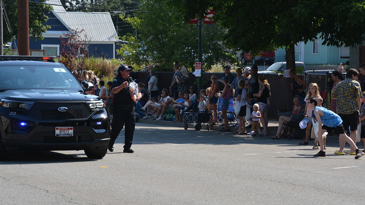 Rathdrum Police Chief Tomi McLean prepares to throw candy to waiting kids during the Rathdrum Days Parade.