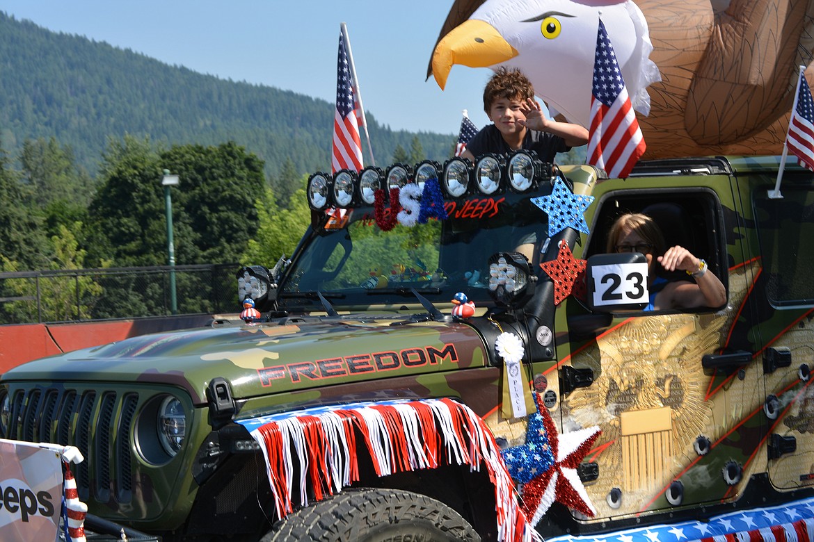 A boy waves from a parade entry from North Idaho Jeep from beneath a giant inflatable bald eagle during the Rathdrum Days Parade.