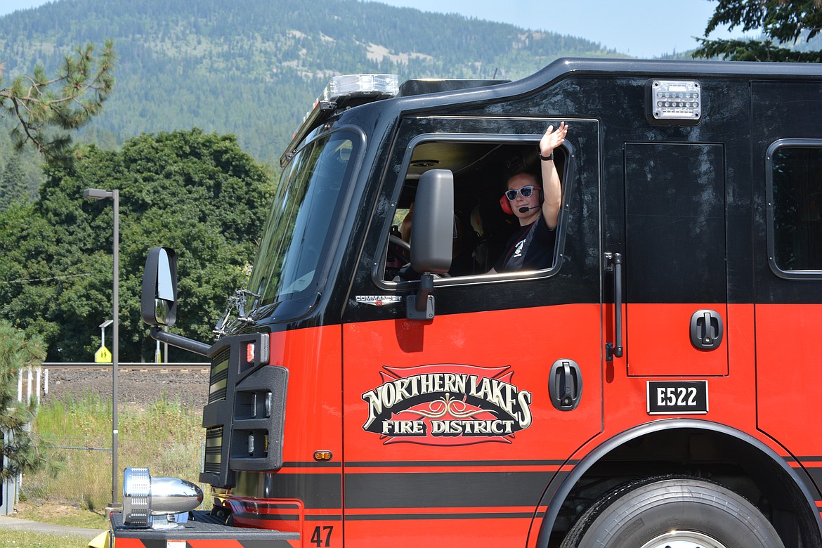 Northern Lakes firefighters wave as they drive down Main Street during the Rathdrum Days Parade.