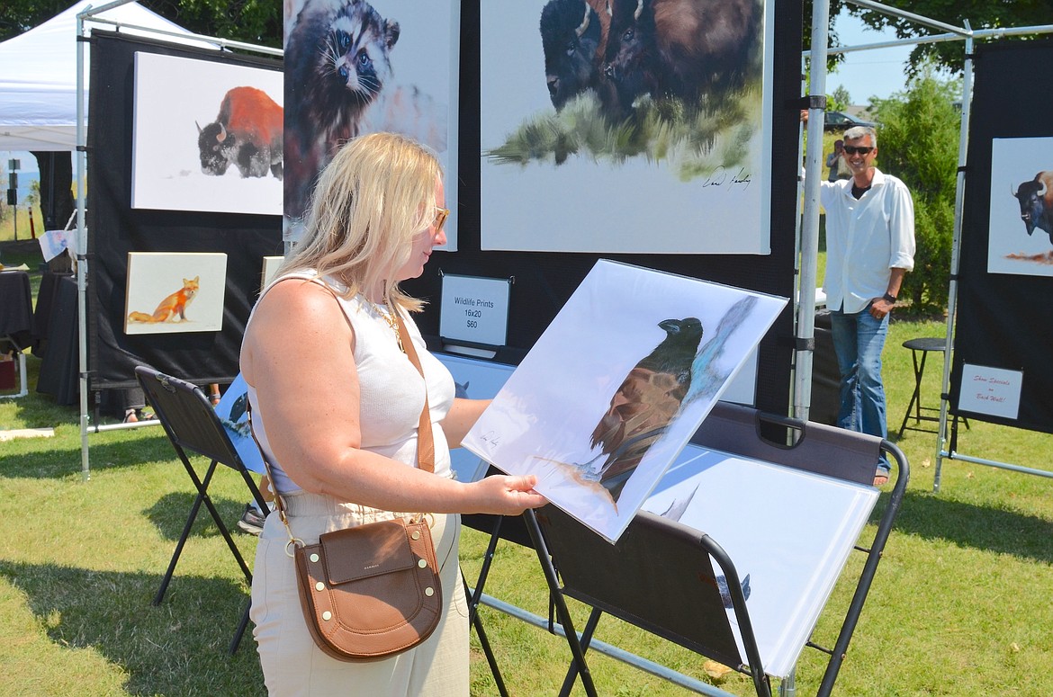 Kallie Gatzemeier of Missoula looks at a raven print by South Dakota artist Jenny Kenyon during the Flathead Lake Festival of Art, held Saturday and Sunday in Sacajawea Park. (Kristi Niemeyer/Leader