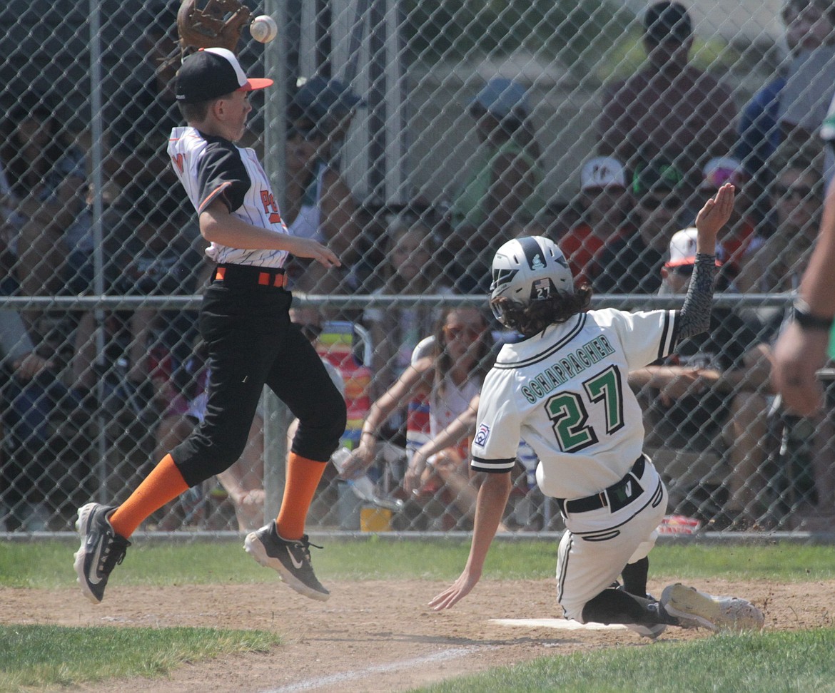 MARK NELKE/Press
Brandt Schappacher (27) of West Valley (of Eagle, Star, Middleton and surrounding areas) slides home safely as Post Falls pitcher Fletcher Tandy fields the throw from the catcher Saturday during Game 2 of a best-of-3 series for the state Little League (12U) championship at Canfield Sports Complex in Coeur d'Alene.