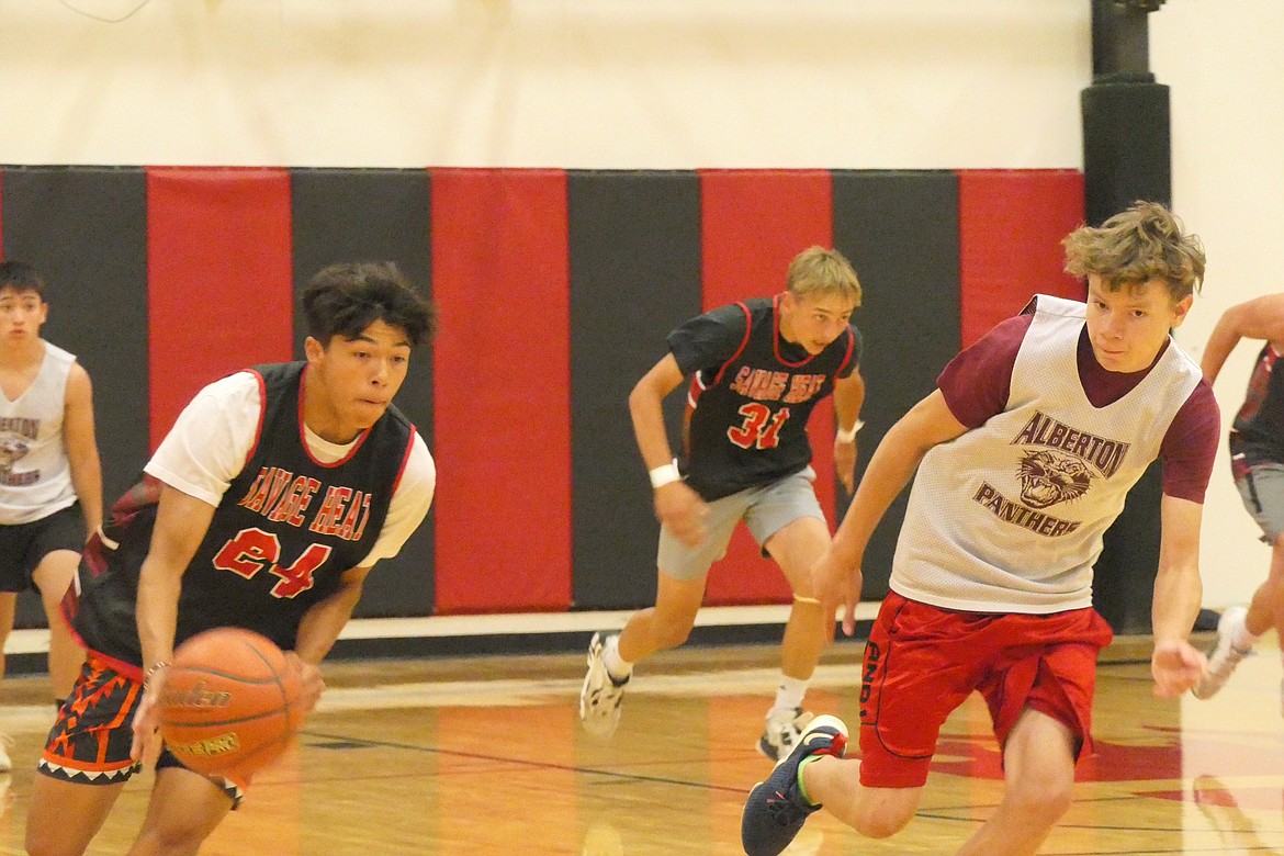 Savage Heat guard Wesley Anderson dribbles downcourt against an Alberton defender during summer basketball action last week in Hot Springs. (Chuck Bandel/VP-MI)