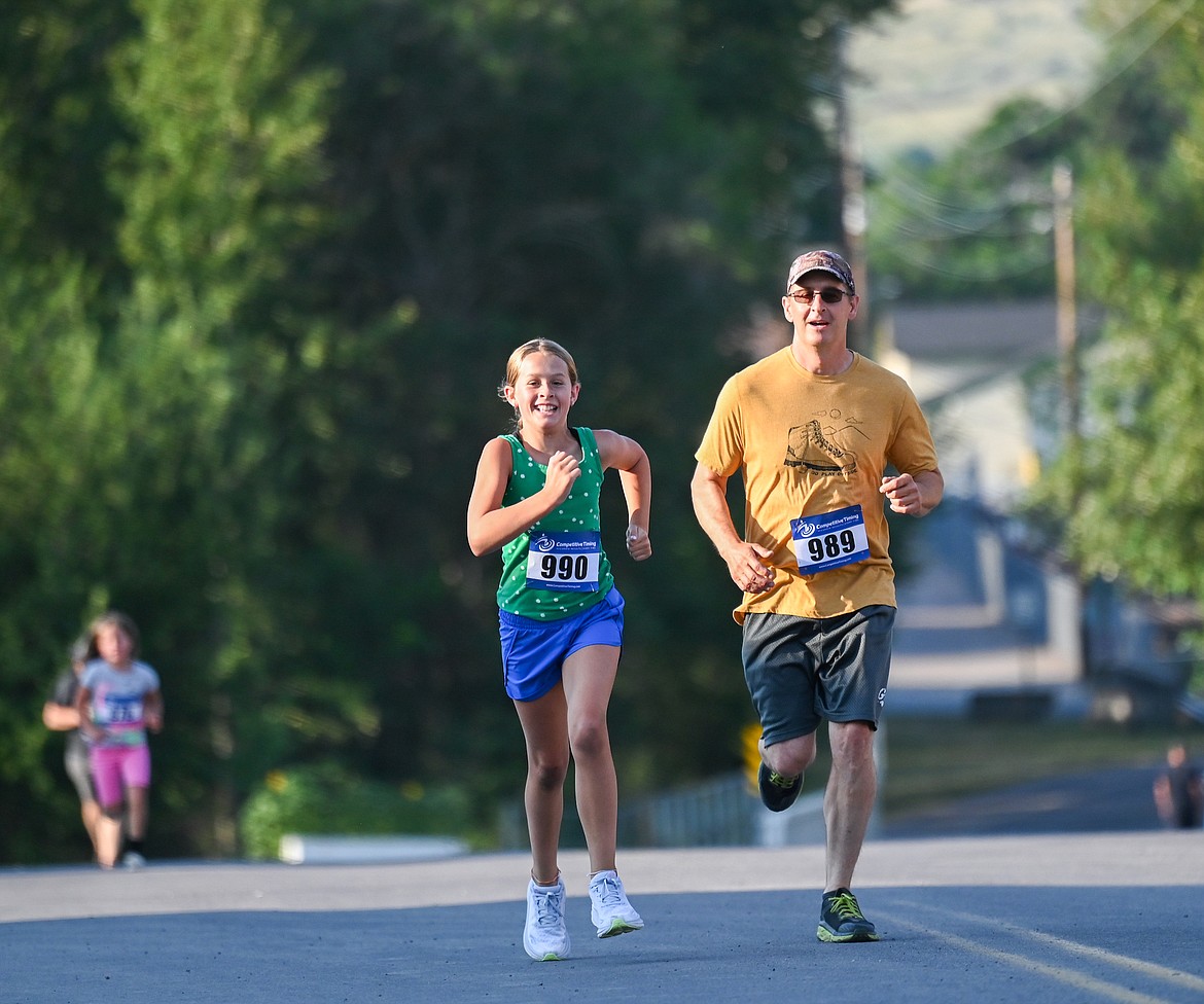 A pair of cheerful running buddies participate in this year's Buffalo Run in St. Ignatius. (Christa Umphrey photo)