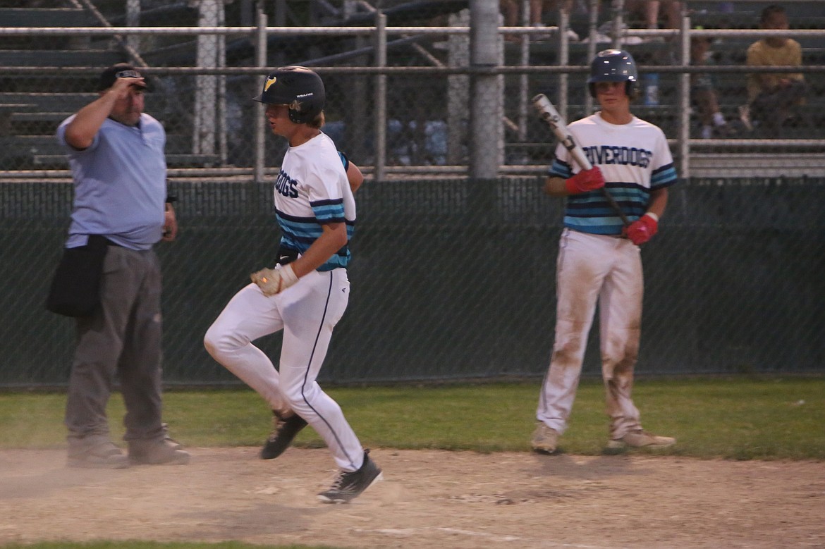 A baserunner for the 18U AA Columbia Basin River Dogs crosses home plate during a July 9 game against the Columbia Basin River Dogs at Larson Playfield in Moses Lake.