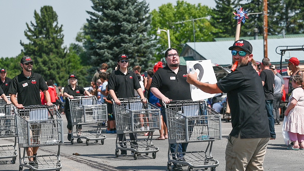 Employees from Rod’s Harvest Foods, led by a kazoo-wielding conductor, pushed a fleet of grocery carts along the Good Old Days parade route on Saturday. (Christa Umphrey photo)