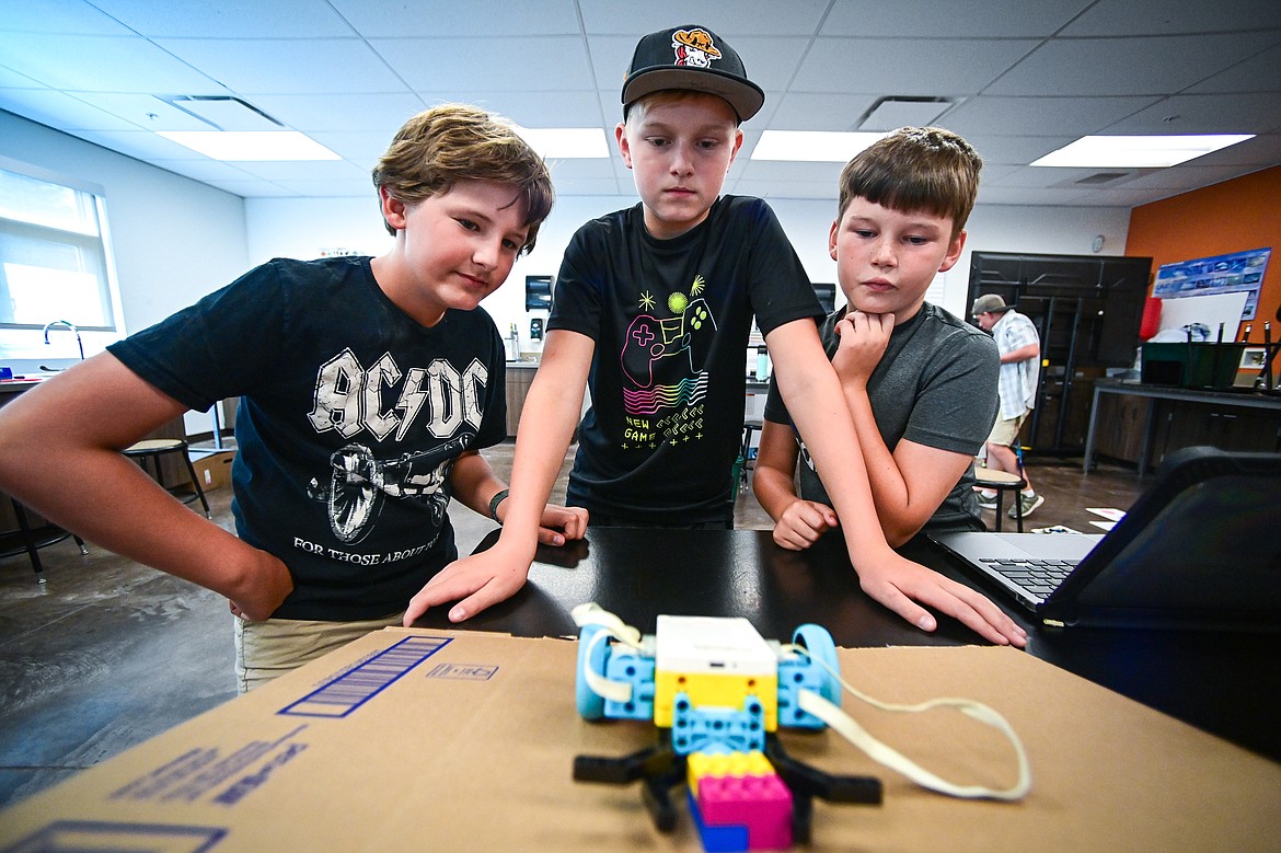 From left, fifth-grader Chance Rasmussen, seventh-grader Austin Hemmelman and fifth-grader Blaine Patterson run tests with their programmable rover so it can effectively deliver a colored block to a specific target on a three-dimensional floor map full of ramps, craters and other details during a Northwest Earth & Space Sciences Pathways Artemis ROADS Mini Mission at West Valley School on Wednesday, July 24. (Casey Kreider/Daily Inter Lake)