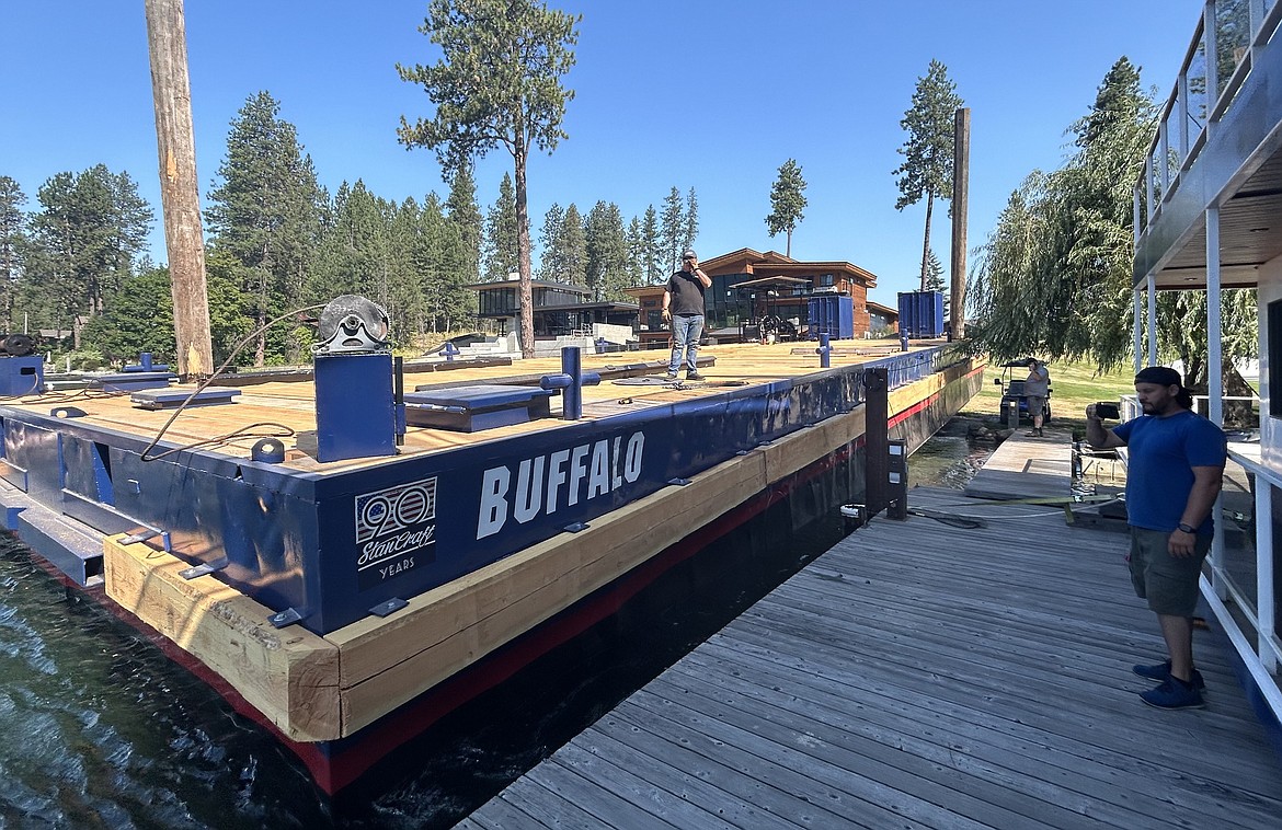 Zach Johnson, general manager of StanCraft Marine Construction, records their renovated barge returning to the water on Wednesday.