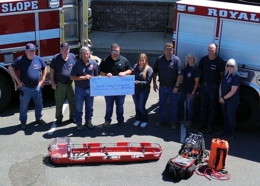 Emergency Service Responders hold a check labeled with $15,000 from CHS Sun Basin Growers. The EMS plan on using the donation to help them purchase additional equipment and help the team for rescue operations at the local climbing areas and at Vantage Bridge.