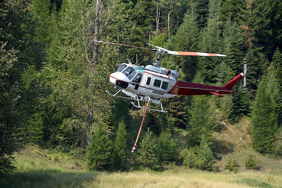 A helicopter gets water from Schrieber Lake east of Libby while fighting the Tepee Fire Thursday. High winds from the Southwest helped the blaze go from two to eight acres in a short amount of time. (Scott Shindledecker/The Western News)