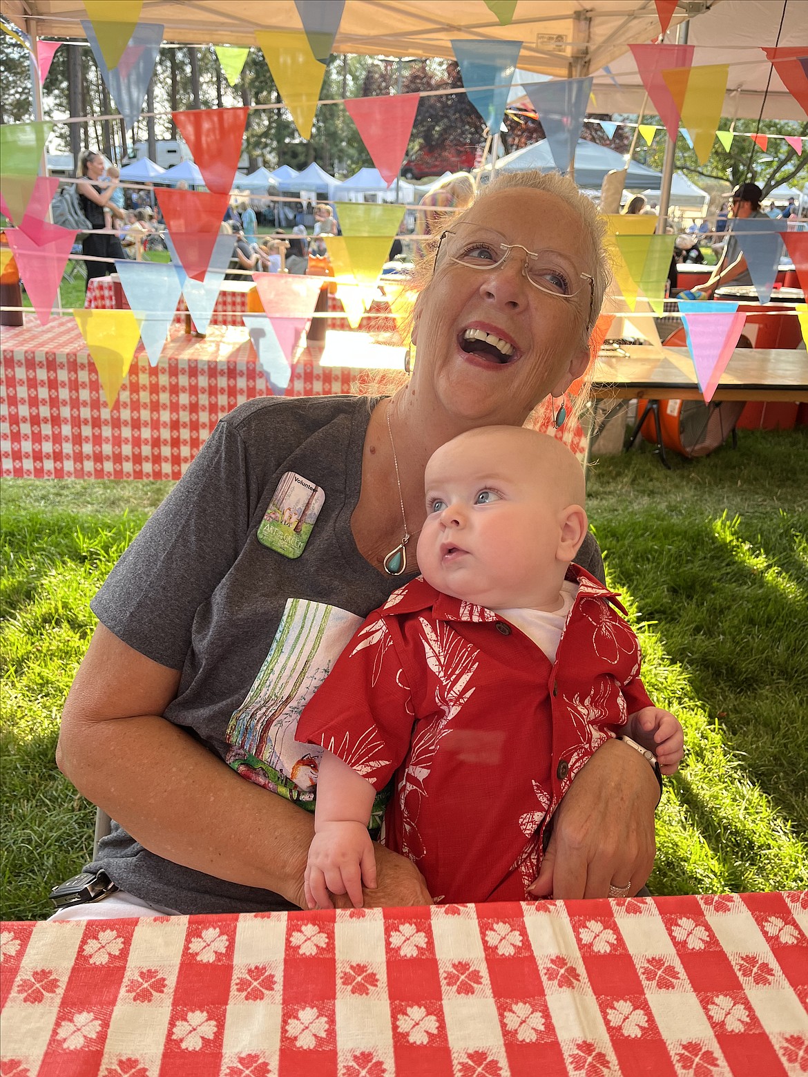 Debbie Harrison and Lincoln Ortega share a moment in the shade during the 2023 Art on the Green. The 2024 Art on the Green is next weekend.