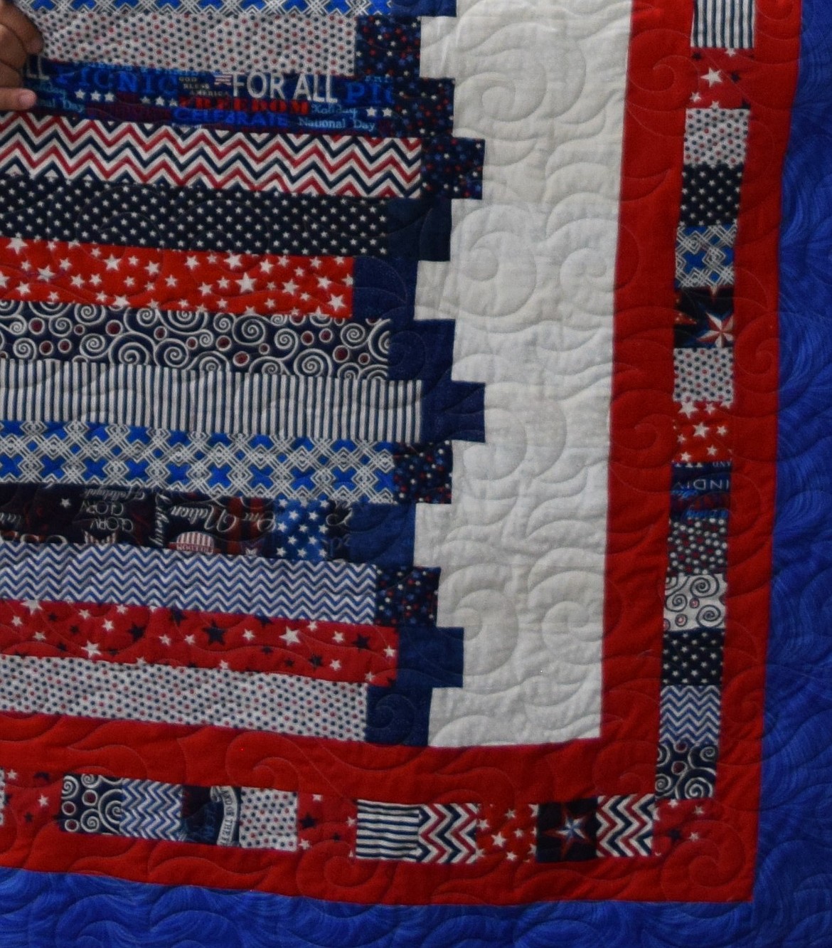 The pattern on the Quilt of Valor award earned by Bill as a veteran of the U.S. military. The Quilts of Valor Foundation works to provide quilts to comfort veterans and recognize them for their service regardless of branch. Each has a set pattern. This one is known as “The Courthouse Steps” and has Bill’s name and the names of the quilters who made it embroidered onto it.