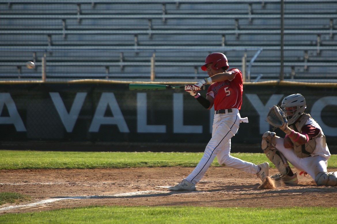 Othello outfielder Noah Ozuna makes contact with a pitch against Walla Walla on Friday. Ozuna was one of the many young players on the Red Raider roster this summer, who all got a taste of the varsity baseball atmosphere.