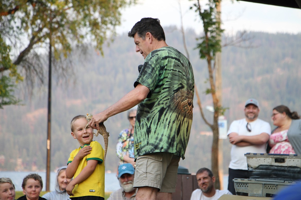 Peterson places a bearded dragon lizard on the shoulder of a young spectator.