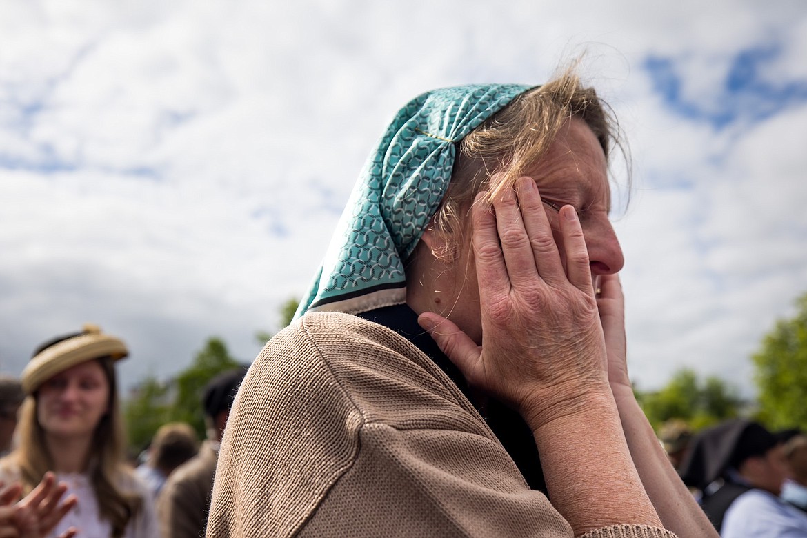 A woman who attended the city-wide parade in Carentan wipes her tears away Saturday, June 8, 2024 after meeting a WWII veteran who took part in the D-Day invasion.