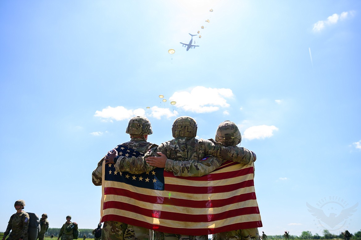 Troops look skyward during a tribute to veterans visiting Normandy in June.