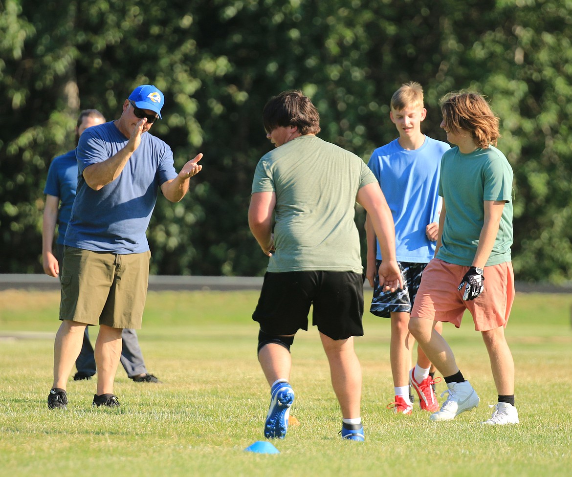 Former Clark Fork High and Eastern Washington University linebacker and tight end Todd Johnson coaches camp participants through a shuffle drill. On the right, waiting to attempt the drill, are Cohen Hawkins of Moscow and Cameron Stewart of Clark Fork.