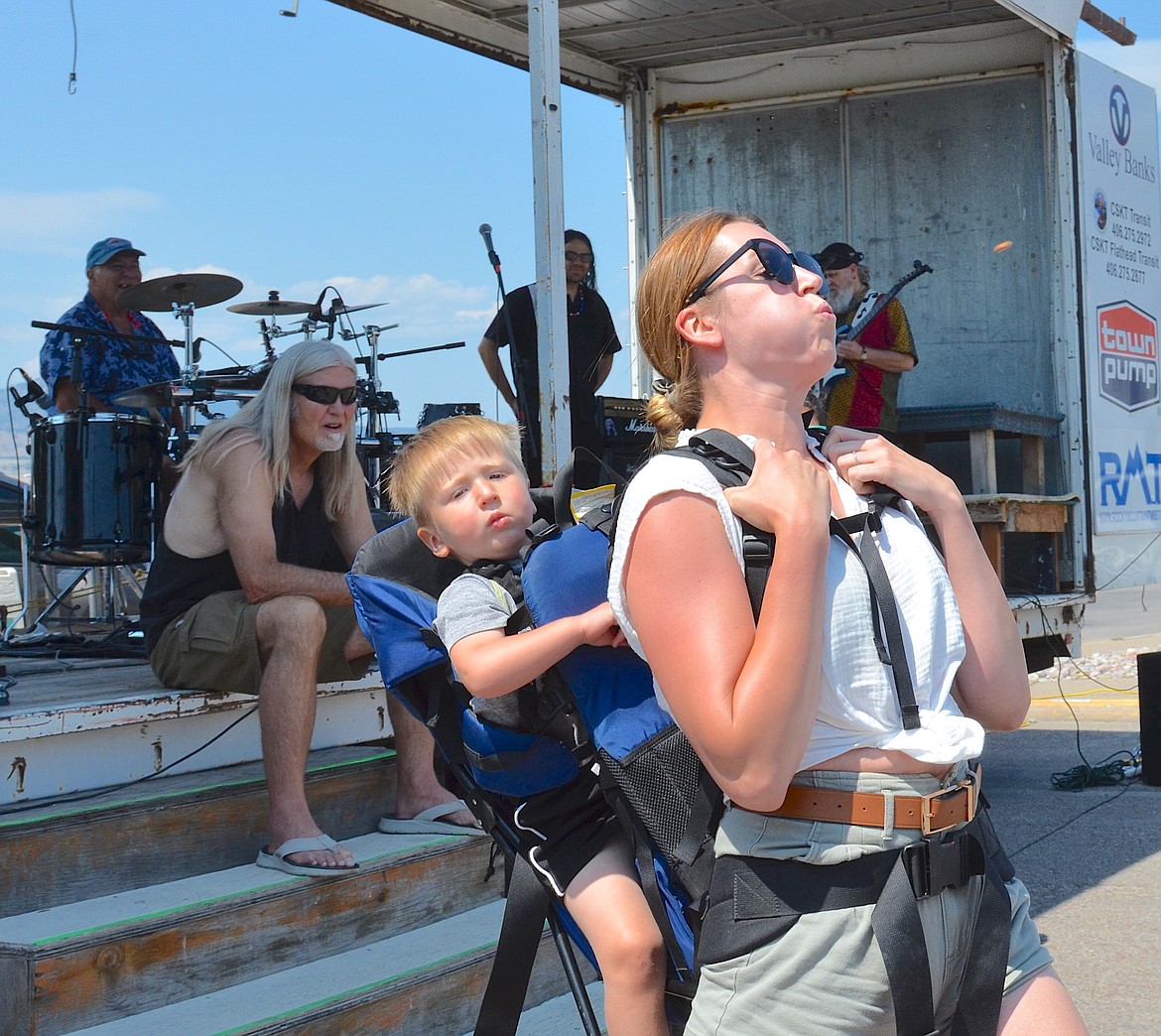 Pint-sized passenger gets an early lesson from his mom in how to propel a cherry pit during Saturday's Flathead Cherry Festival. (Kristi Niemeyer/Leader)