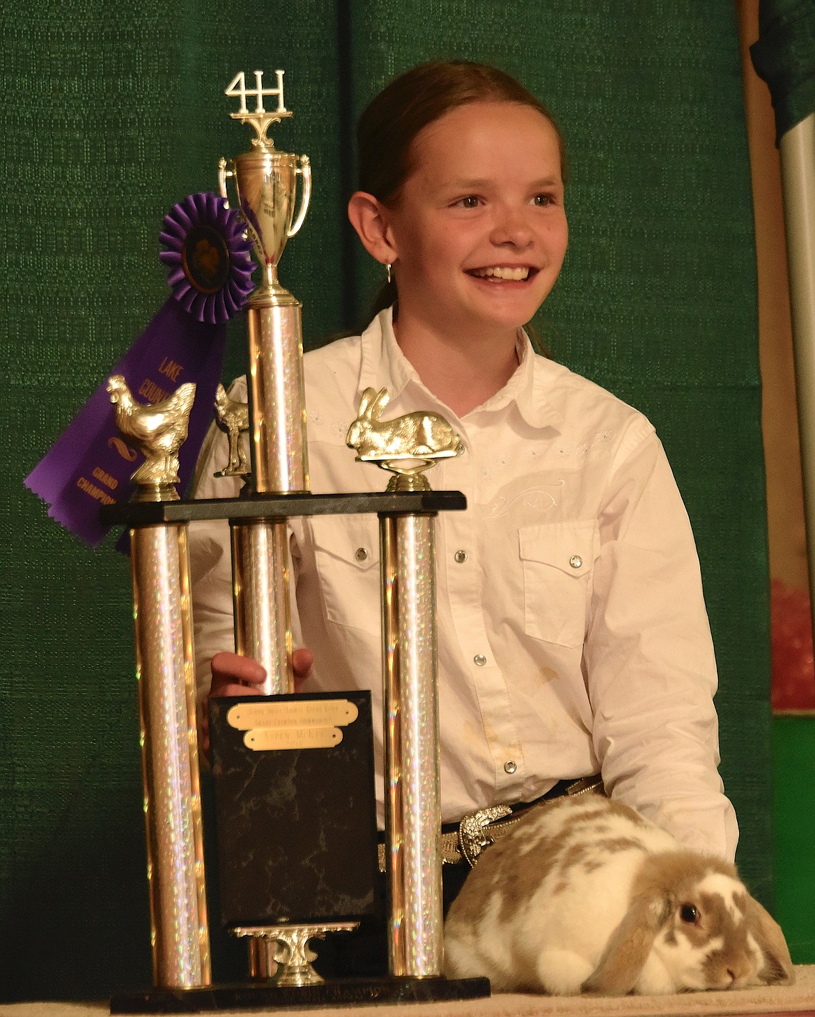 Junior Small Animal Round Robin Grand Champion Ella Dupuis and her bunny pose with her trophy and ribbon. (Berl Tiskus/Leader)