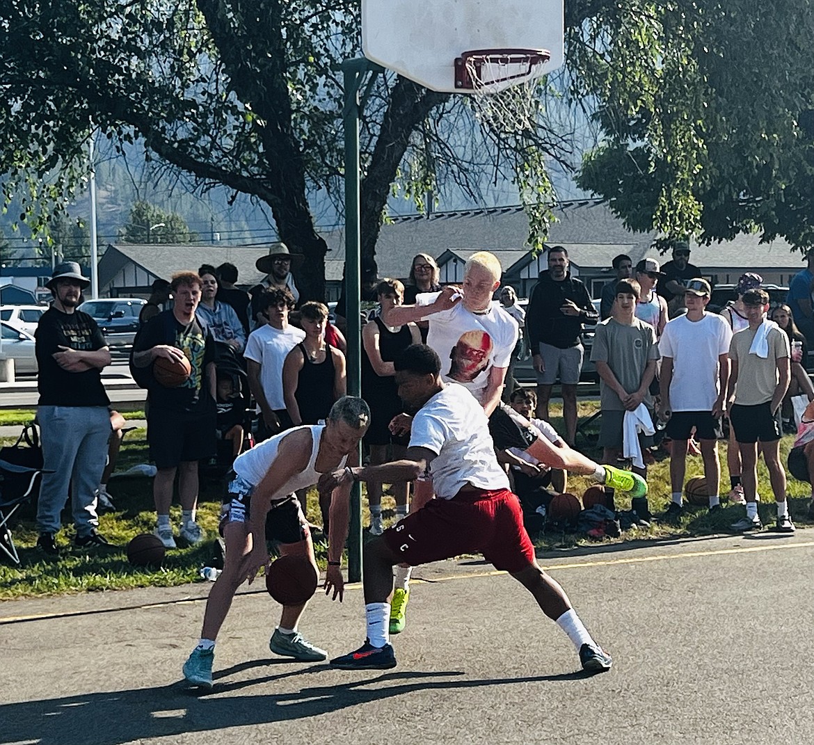 Cayden Honnerlaw attempts to block a shot while teammate Dalton Coburn steals the ball during a game at the SilverHoops 3-on-3 Basketball Tournament.