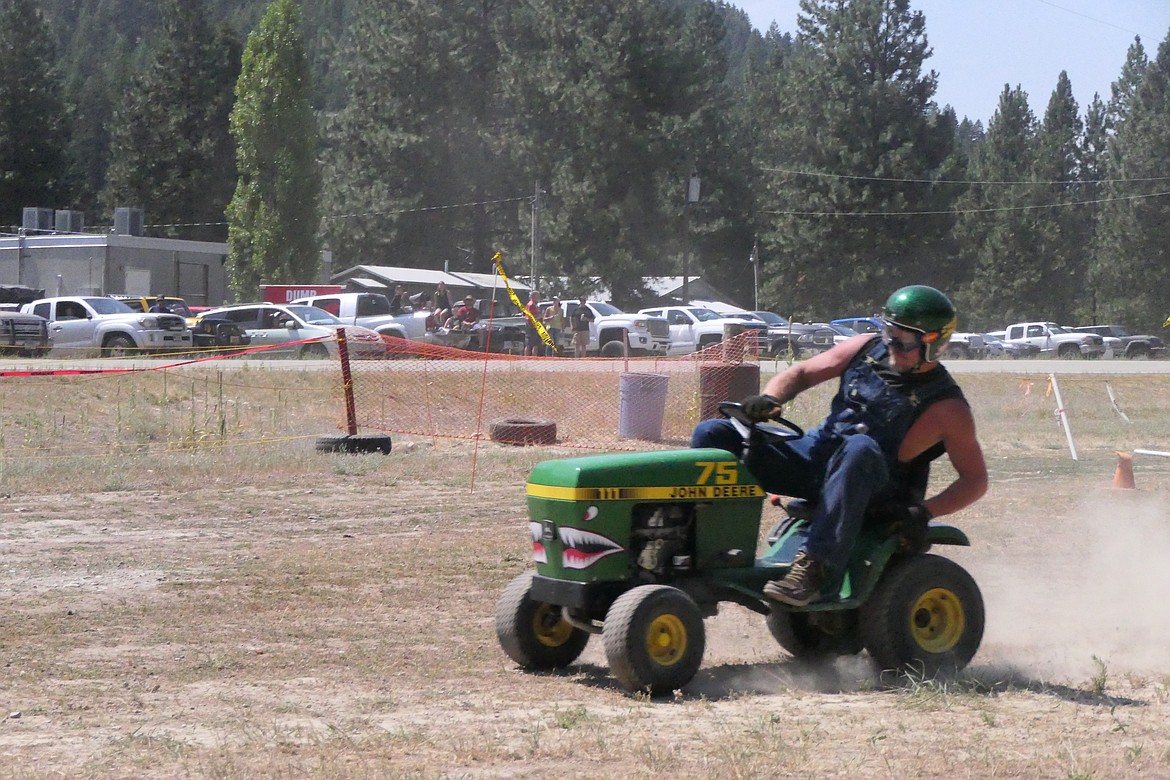 A contestant in the Wild Coyote Saloon Days riding lawn mower race roars around the quarter-mile dirt track across from the saloon this past Saturday.  (Chuck Bandel/VP-MI)