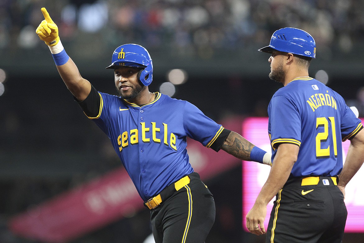 JASON REDMOND/Associated Press
Seattle Mariner outfielder Victor Robles celebrates next to first base coach Kristopher Negron after getting a hit in a June 14 game against the Texas Rangers in Seattle. Robles, acquired after being designated for assignment by the Washington Nationals, has been a bright spot of late in the absence of Julio Rodriguez due to injury.