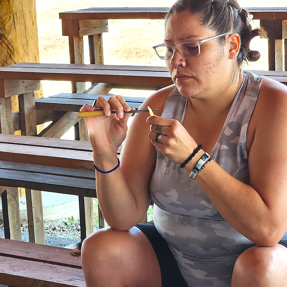 A Culture Club attendee works with a file and a shard of elk femur to fashion a traditional Kootenai needle.(Berl Tiskus/Leader)