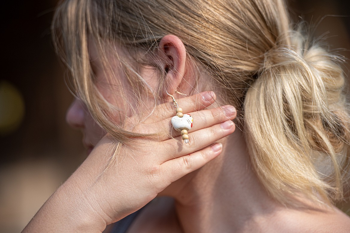 Sage Harapat shows off her chicken earrings. (Avery Howe/Bigfork Eagle)