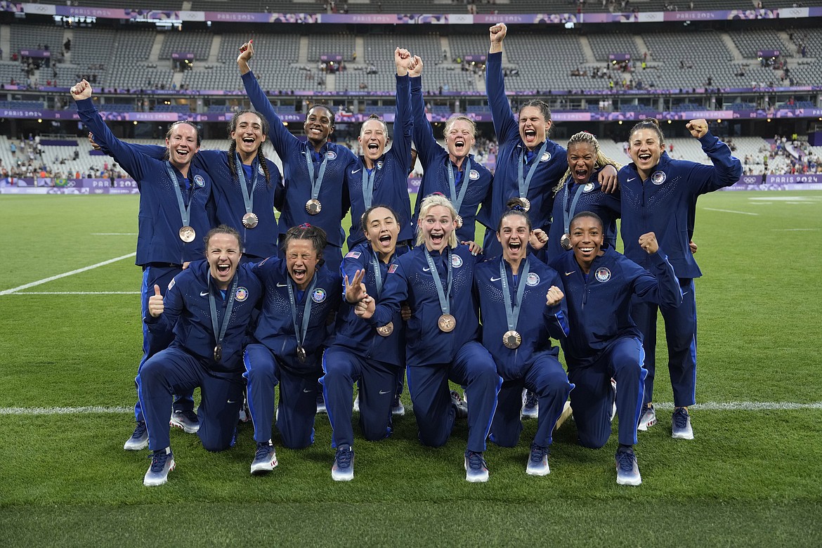 Members of the United States Rugby Sevens team pose for the media with their bronze medals after the medals ceremony at the 2024 Summer Olympics, in the Stade de France, in Saint-Denis, France, Tuesday, July 30, 2024. (AP Photo/Vadim Ghirda)