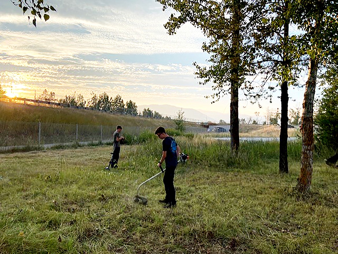 Mason and Boston Blaser work to knock down weeds as part of a community project by the Sandpoint Ward youth group, part of the Church of Jesus Christ of Latter-day Saints.