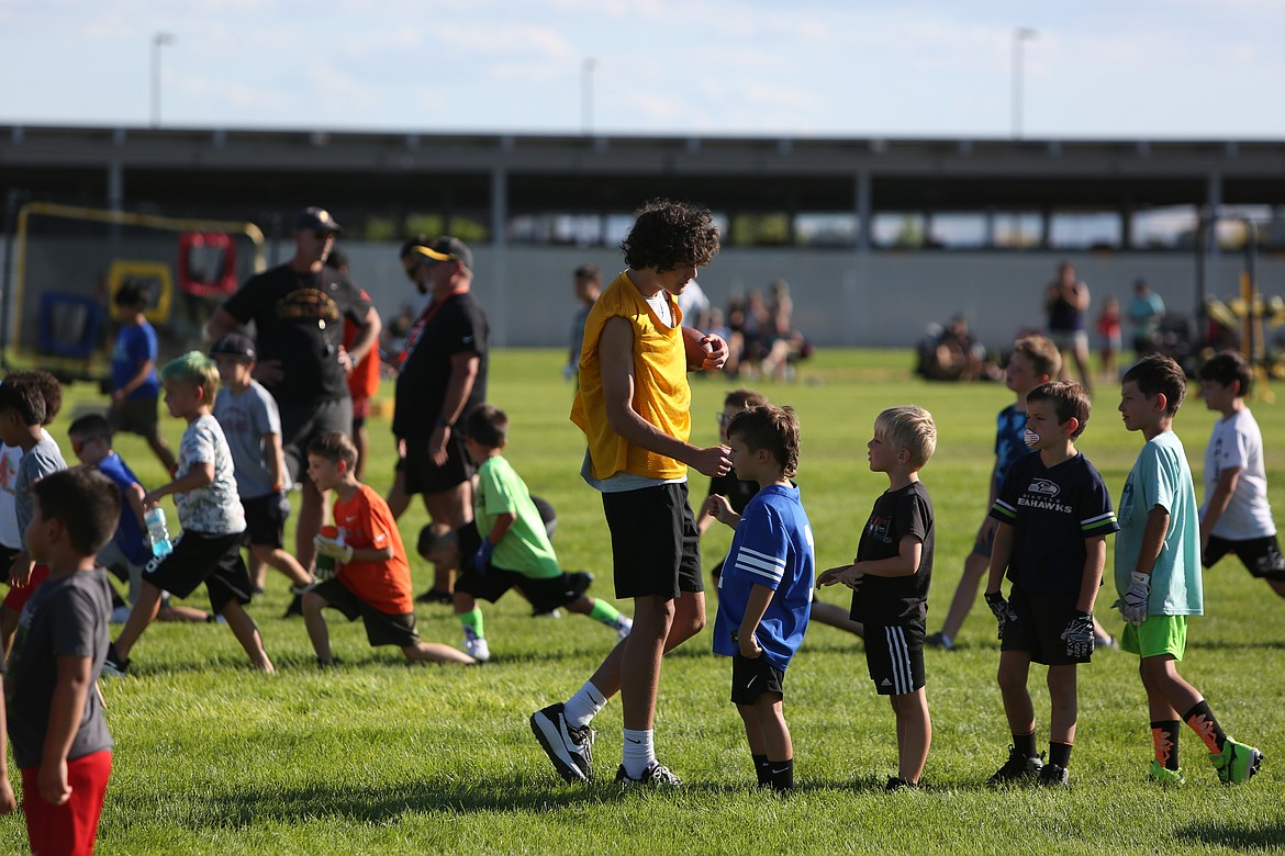 A Mavericks football player high-fives a camper at the Mav Youth Football Camp on Tuesday.