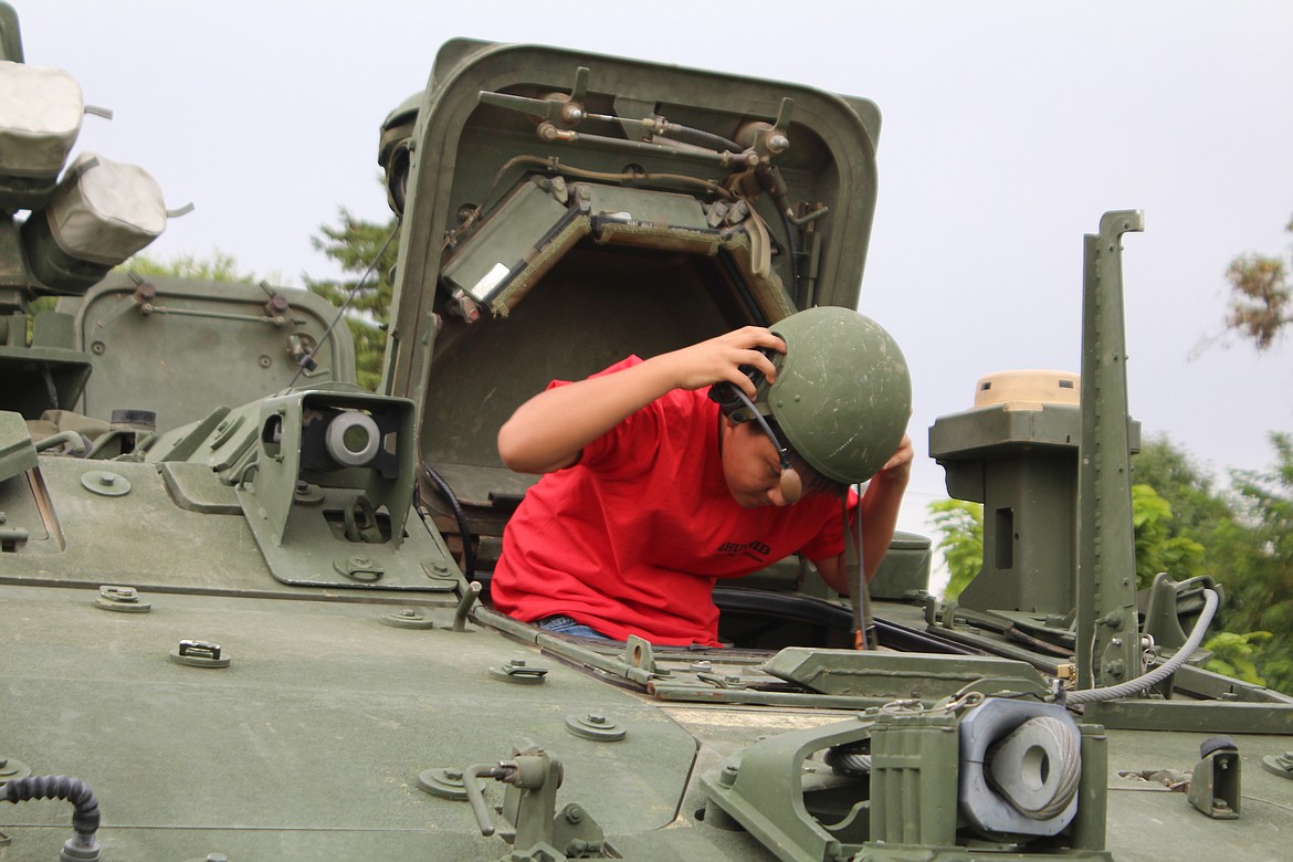 A curious child tries on a Stryker driver’s helmet at Mattawa’s National Night Out in 2023. This year’s event in Mattawa is Aug. 9.