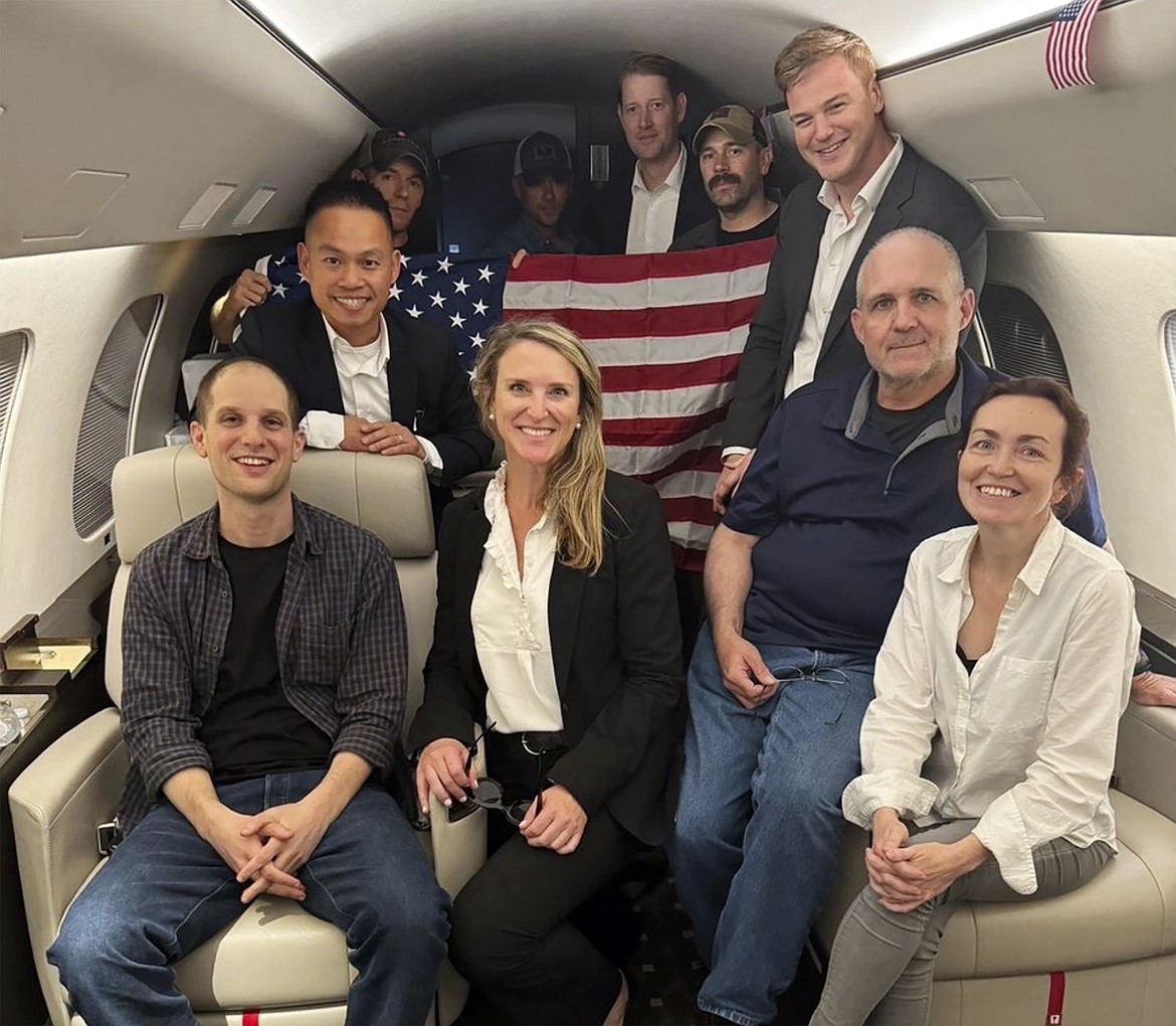 This image released by the White House shows Evan Gershkovich, left, Alsu Kurmasheva, right, and Paul Whelan, second from right, and others aboard a plane, Thursday, Aug. 1, 2024, following their release from Russian captivity. (White House via AP)