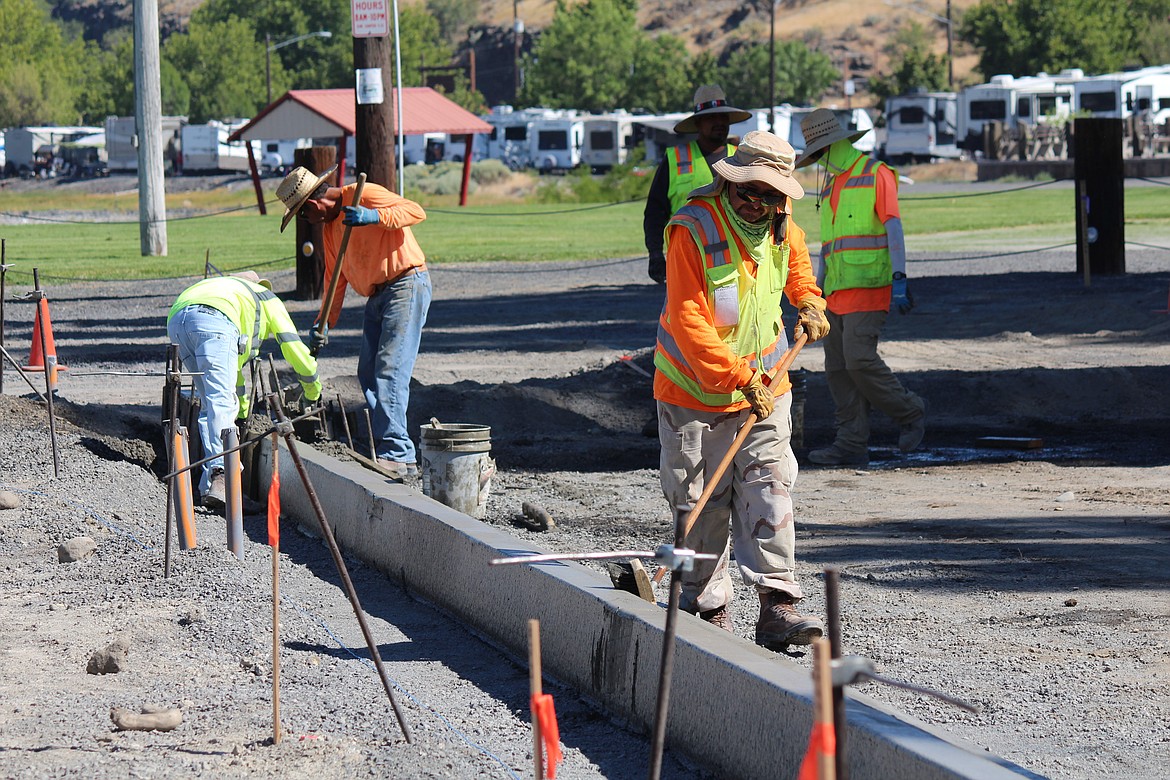 A construction worker adds a brush finish to a concrete curb along Marina Way in Soap Lake Thursday.