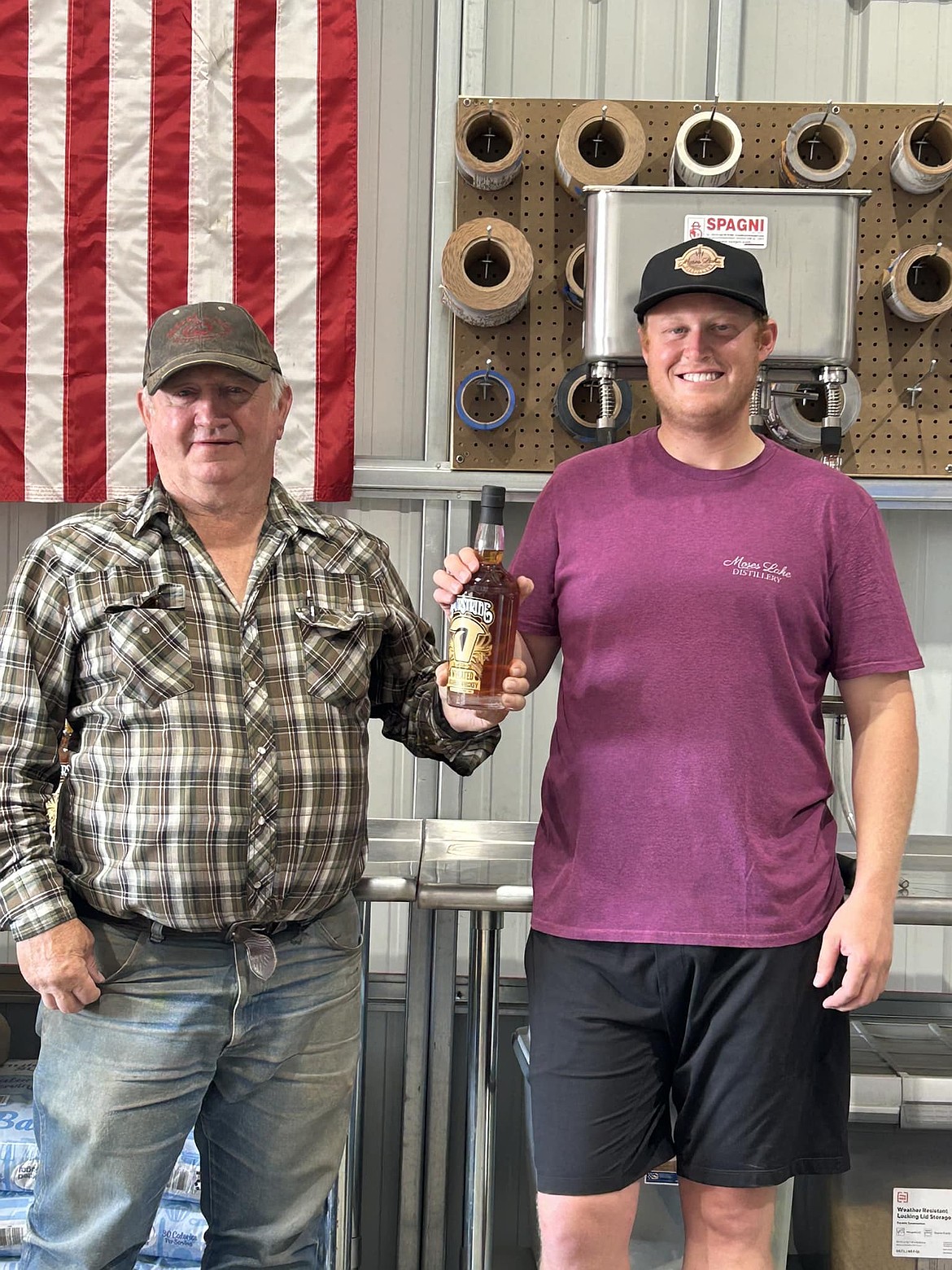 Moses Lake Roundup Rodeo Board President Chris Starzman, left, and Moses Lake Distillers Owner Zach Hughes show off a bottle of the rodeo’s new signature whiskey, Spurstride.