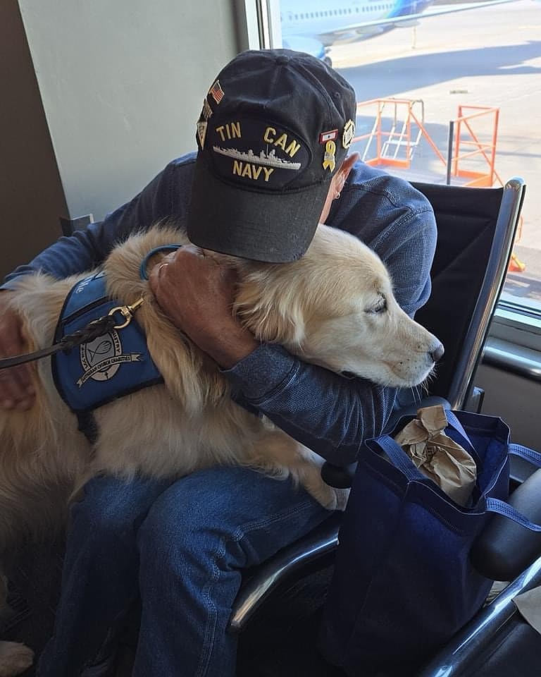 Isaac the comfort dog gets a hug from a veteran during a past Honor Flight.