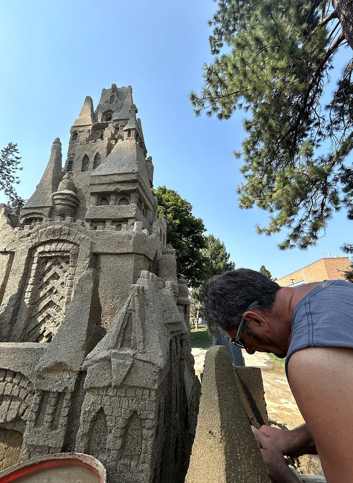 Scott Dodson works on a sandcastle at Art on the Green on Friday.